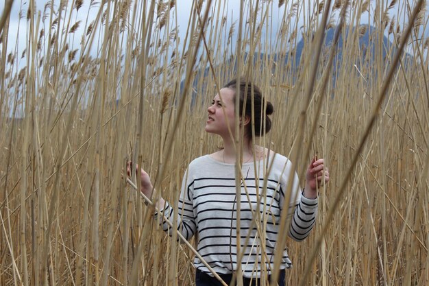 Foto frau steht bei pflanzen auf dem feld