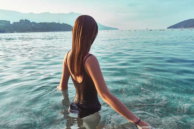 Frau steht im klaren türkisfarbenen ruhigen Wasser