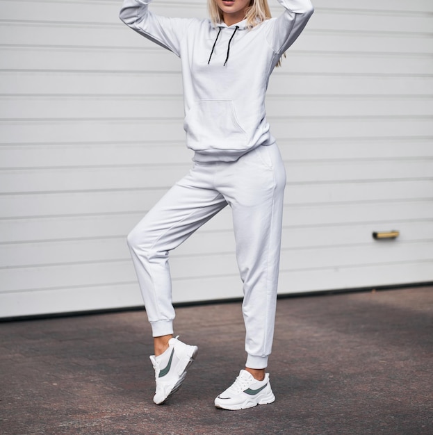 Frau steht im weißen Anzug Stilvolle Streetwear ohne Logos oder Bilder auf blonden Mädchen