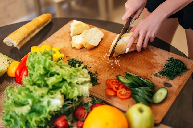 Frau steht in der Küche und kocht Salat mit gesundem Essen