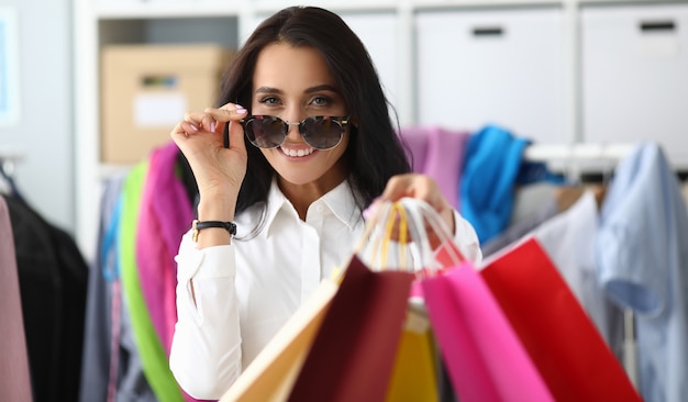 Frau stellt Brille von Sonne ein, die Pakete zeigt