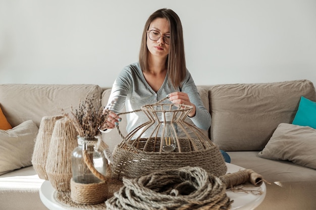 Frau stellt zu Hause handgefertigte DIY-Lampe aus Juteseil her