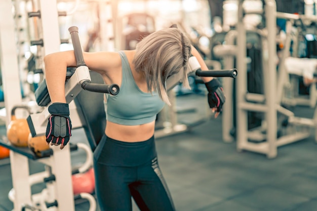 Frau streckt die Arme und bereitet sich vor dem Training im Fitnessstudio vor