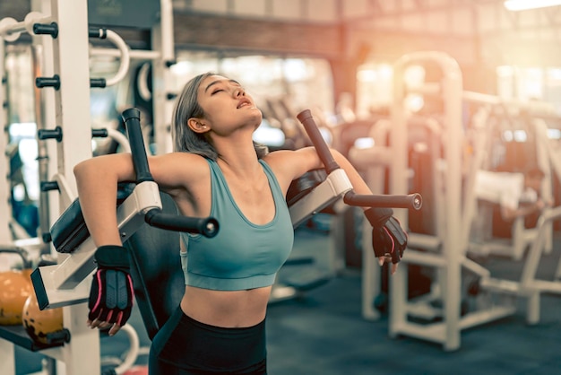 Frau streckt die Arme und bereitet sich vor dem Training im Fitnessstudio vor