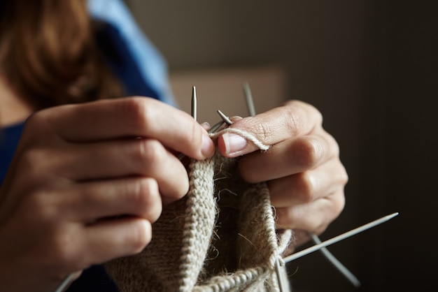 Frau strickt Socken mit Nadeln