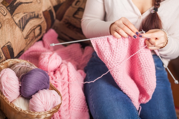 Frau strickt Wollkleidung