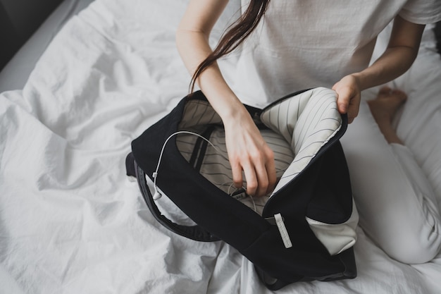 Frau sucht etwas in einem Rucksack