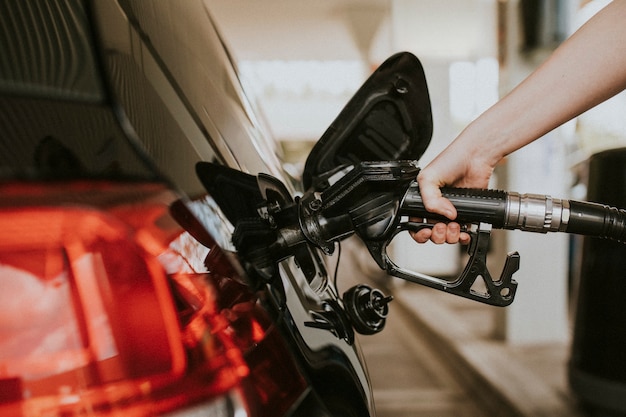 Frau tanken an einer Tankstelle