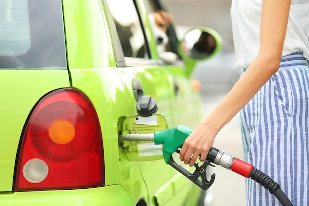 Frau tankt Auto an Tankstelle