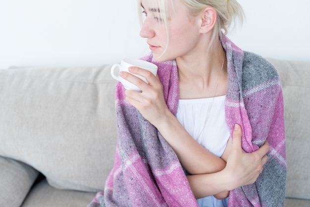 Frau Tasse bedeckt Decke entspanntes Wochenende nach Hause