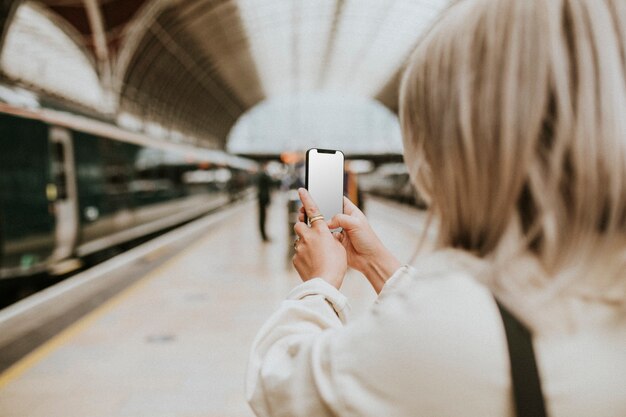 Frau telefoniert am Bahnhof