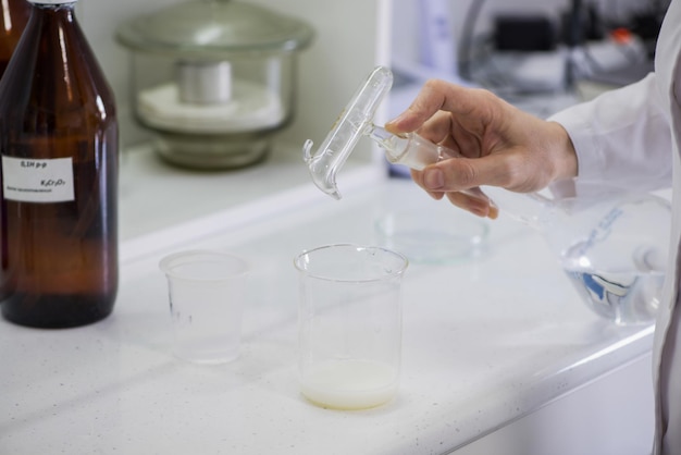 Frau testet proben von milchprodukten im labor. prüflabor einer milchfabrik