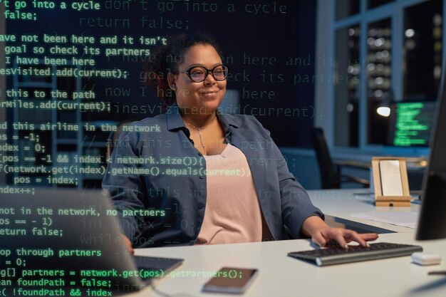 Frau tippt Codes am Computer im Büro ein