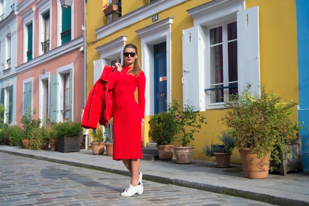 Frau total rotes Outfit genießen Spaziergang schöne Straße Paris. Pariser unbeschwerte Spaziergänge an einem sonnigen Tag. Lass uns gehen. Freizeit- und Kulturattraktionen in Paris. Reiseführer für die Freizeit in der französischen Hauptstadt.