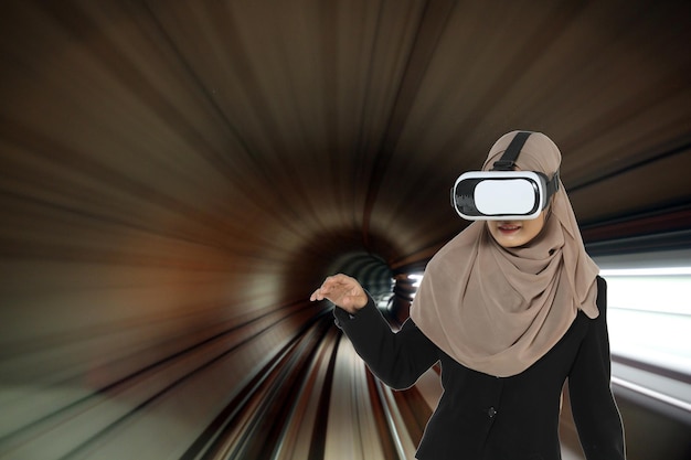 Foto frau trägt einen virtual-reality-simulator, während sie auf der schiene gebärdet