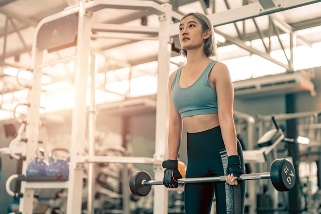 Foto frau trainiert im fitnessstudio mit sportgeräten sportliche weibliche übung mit krafttraining im fitnessstudio