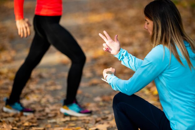 Foto frau trainiert im öffentlichen park mit einem persönlichen trainer im herbst, der sprünge zählt