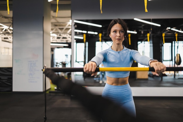 Frau trainiert mit einem Trx-Rip-Trainer im Fitnessstudio