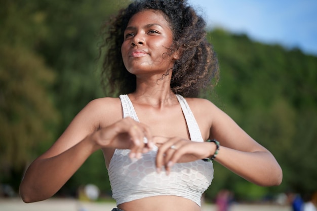 Frau trainiert und dehnt Muskeln vor dem Training im Freien Portrait sexy asiatische afrikanische Dame bereitet sich auf Fitness am Strand vor