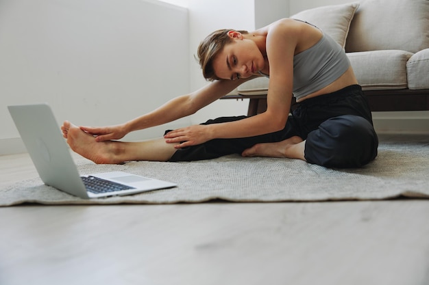 Frau trainiert zu Hause per Video-Workout, Online-Meditation und dehnt ihre psychische Gesundheit aus