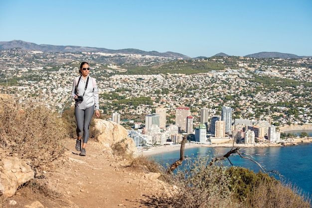 Frau Trekking entlang eines Pfades im Naturpark von Peñon de Ifach in Calpe, Sportbekleidung tragend