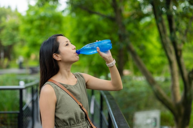 Frau trinkt eine Wasserflasche im Freien