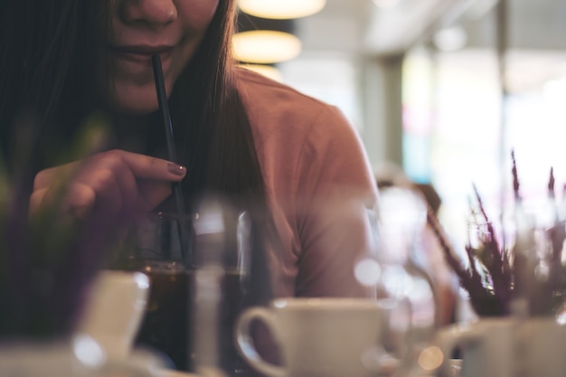 Frau trinkt Eiskaffee mit Strohhalm