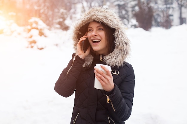 Frau trinkt ihr heißes Getränk aus der Tasse Wintersaison