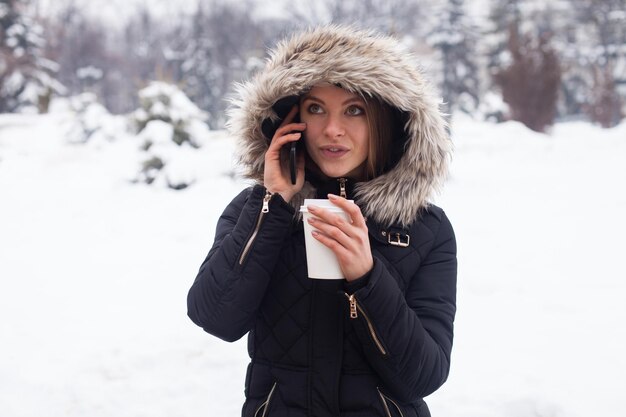 Frau trinkt ihr heißes Getränk aus der Tasse Wintersaison