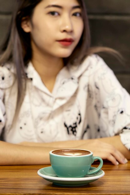 Frau trinkt Kaffee auf dem Tisch