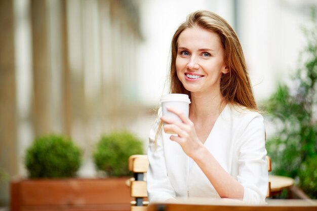 Frau trinkt Kaffee im Straßencafé