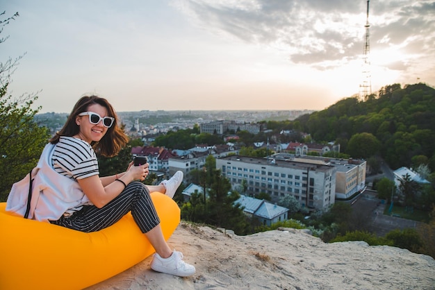 Frau trinkt Kaffee mit schöner Aussicht auf den Sonnenuntergang über der Stadt Lemberg in der Ukraine