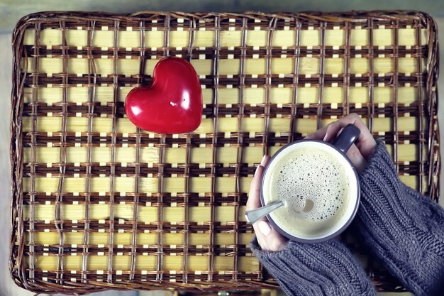 Frau trinkt Kaffee und schaut sich die Karte zum Valentinstag an