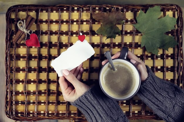 Frau trinkt Kaffee und schaut sich die Karte zum Valentinstag an