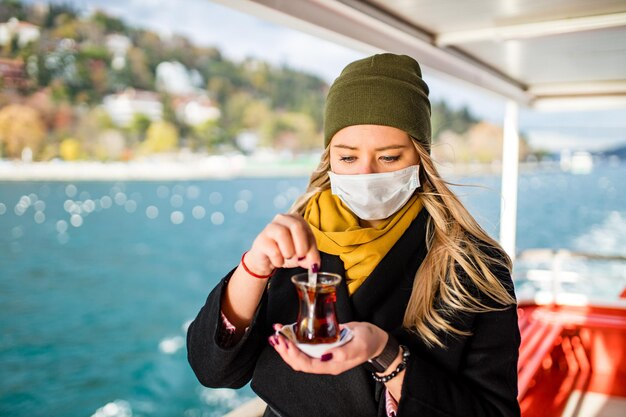 Frau trinkt Masala-Tee in der vorderen Bosporus-Bucht im Hintergrund