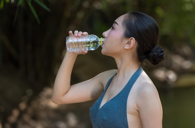 Frau trinkt Wasser im Freien.