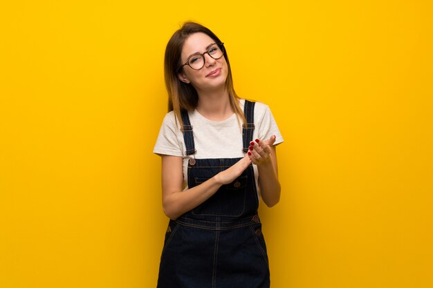 Frau über der gelben Wand, die nach Darstellung in einer Konferenz applaudiert