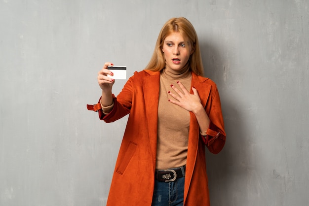 Frau über strukturiertem Hintergrund mit dem gestörten Halten des gebrochenen Smartphone