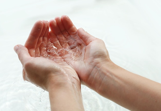 Frau übergibt Hintergrund des klaren Wassers