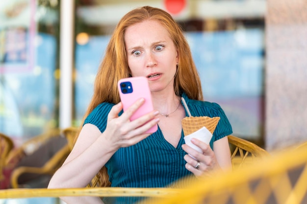 Frau überrascht von etwas, das sie mit ihrem Smartphone betrachtet