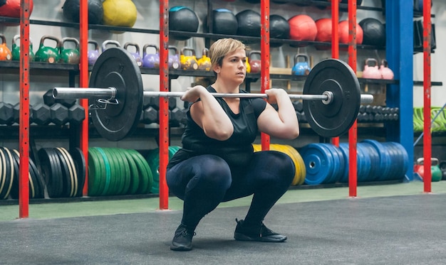 Foto frau übt gewichtheben im fitnessstudio