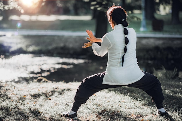 Foto frau übt tai chi quan im park