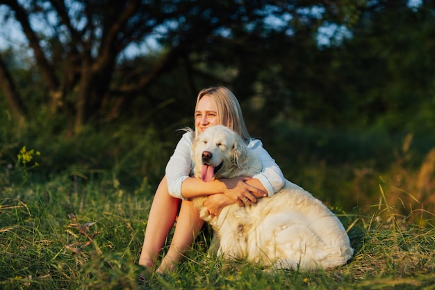 Frau umarmt Hund im Park