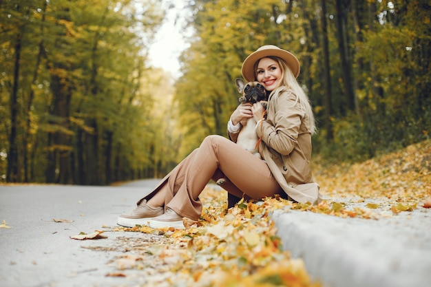 Frau und Hund spielen und haben Spaß im Herbstpark