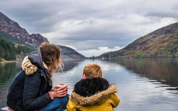 Foto frau und kind am see gegen die bergkette