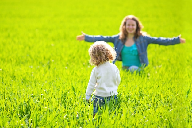 Frau und Kind spielen Verstecken im Sommerfeld