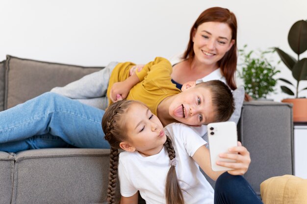 Foto frau und kinder mit mittlerer aufnahme machen selfie