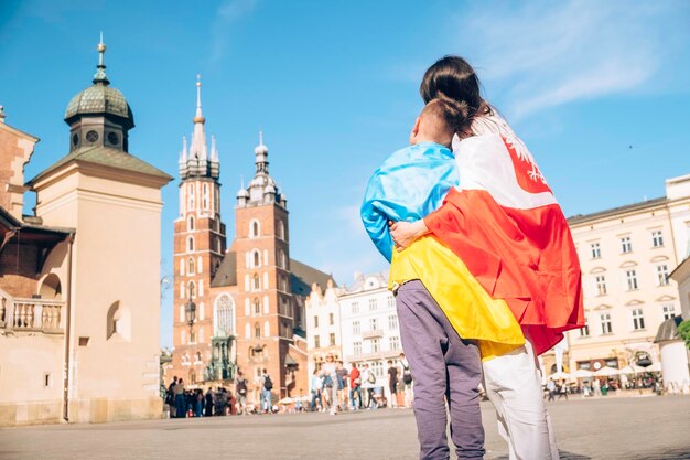 Frau und kleiner Junge mit ukrainischer und polnischer Flagge im Stadtzentrum