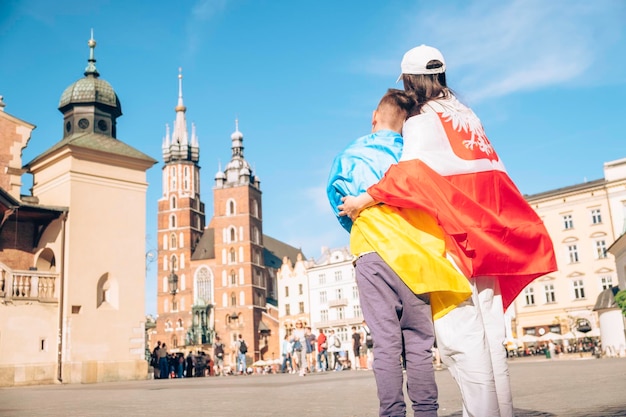 Frau und kleiner Junge mit ukrainischer und polnischer Flagge im Stadtzentrum