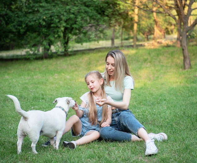Frau und kleines Mädchen spielen mit einer Hunderasse Jack Russell Terrier